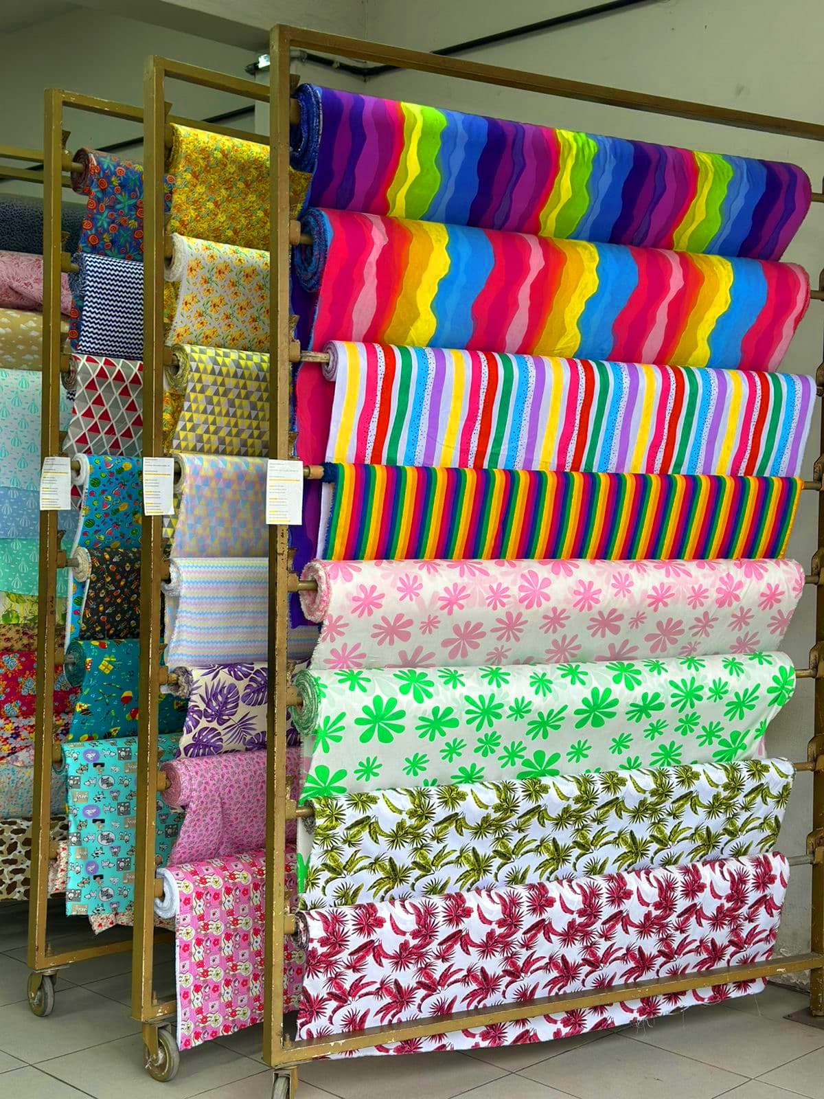 Interior da Tecil Tecidos em Caruaru, com racks de tecidos estampados